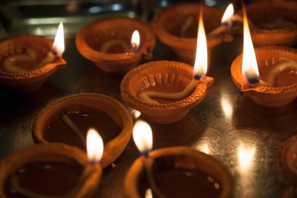 Home Page New 1 Traditional clay diyas lit with flames for Diwali festival celebration.